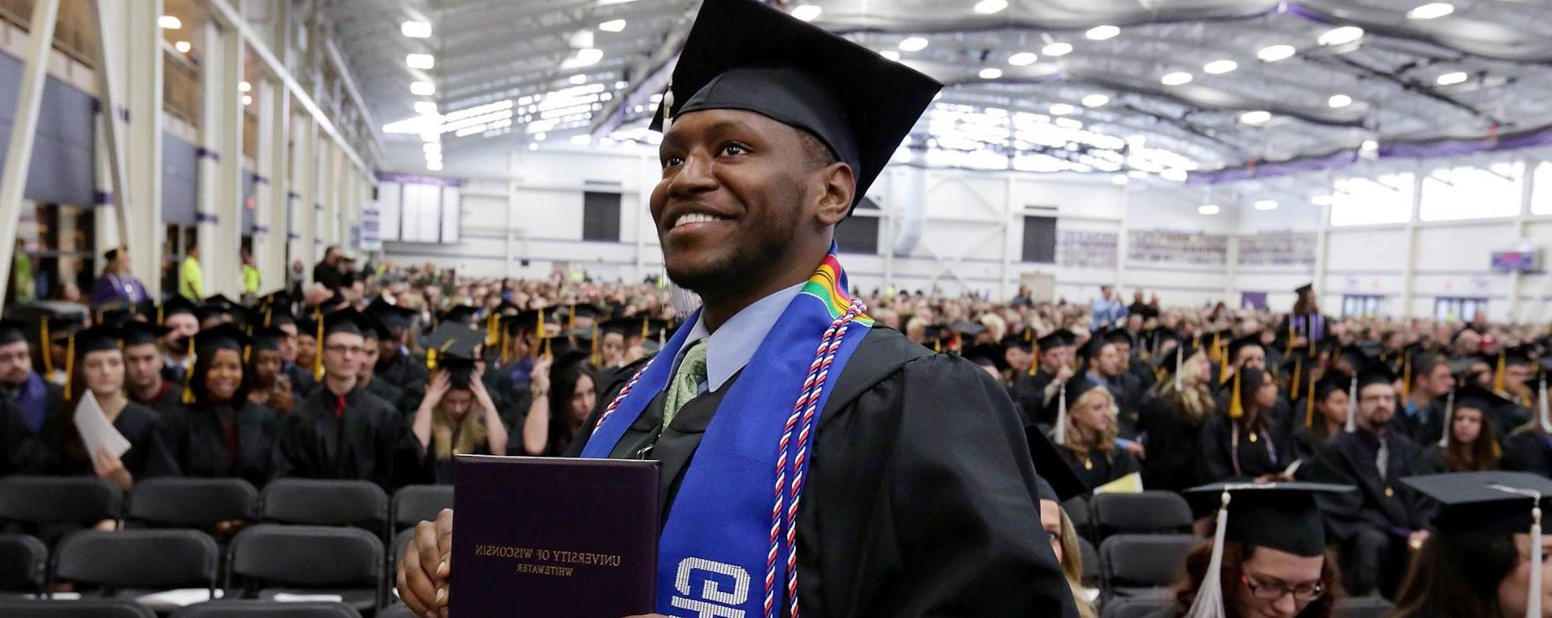 A student holds his diploma at commencement.